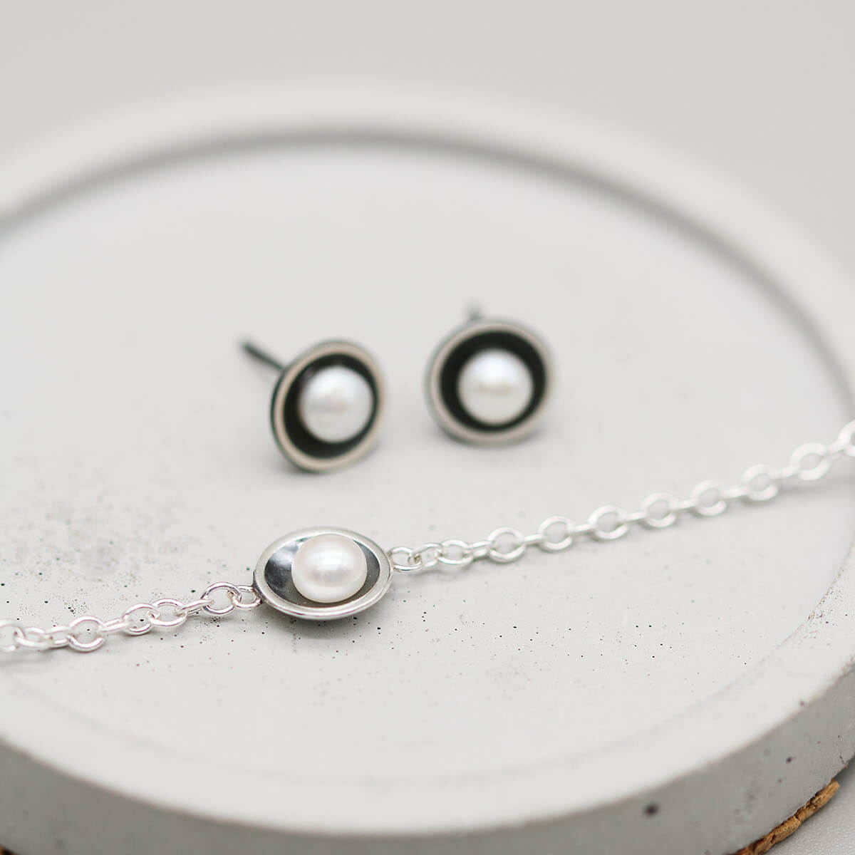 Handmade pearl and sterling silver bracelet photographed with coordinating black pearl stud earrings from the matching jewellery collection.