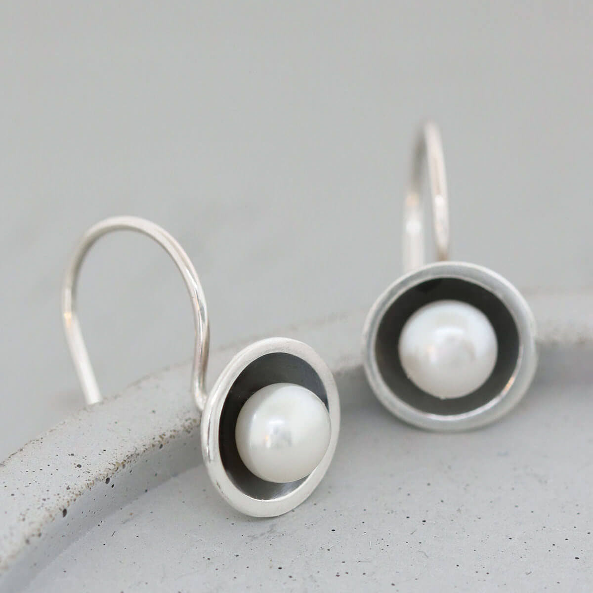 Close-up of black pearl drop earrings featuring freshwater pearls set in handcrafted oxidised sterling silver.