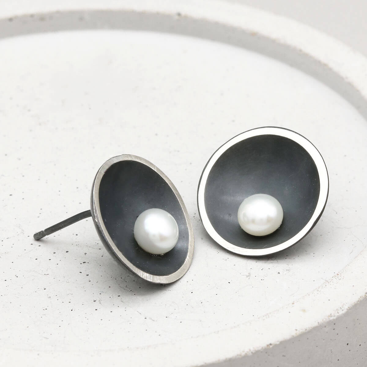 Close-up of Signature Black Pearl Stud Earrings featuring handcrafted oxidised sterling silver and genuine freshwater pearls.