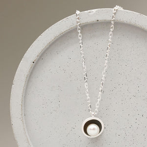 Close-up of an oxidised sterling silver black pearl pendant necklace showcasing a single freshwater pearl.
