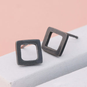 xidised black square silver stud earrings on grey dish, modern square stud earrings