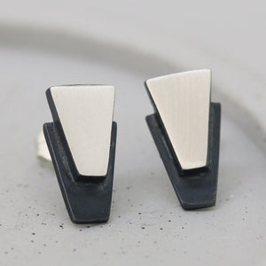 Minimal black stud earrings for women shown on grey dish, sterling silver finish great for everyday wear or bridesmaid gifting.