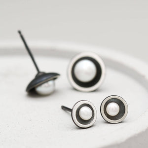 Petite and Classic black pearl stud earrings shown side by side to compare the two sizes.