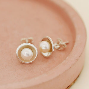 Handmade real pearl stud earrings displayed on a soft pink dish — modern Pearl Earrings for women with a timeless feel.