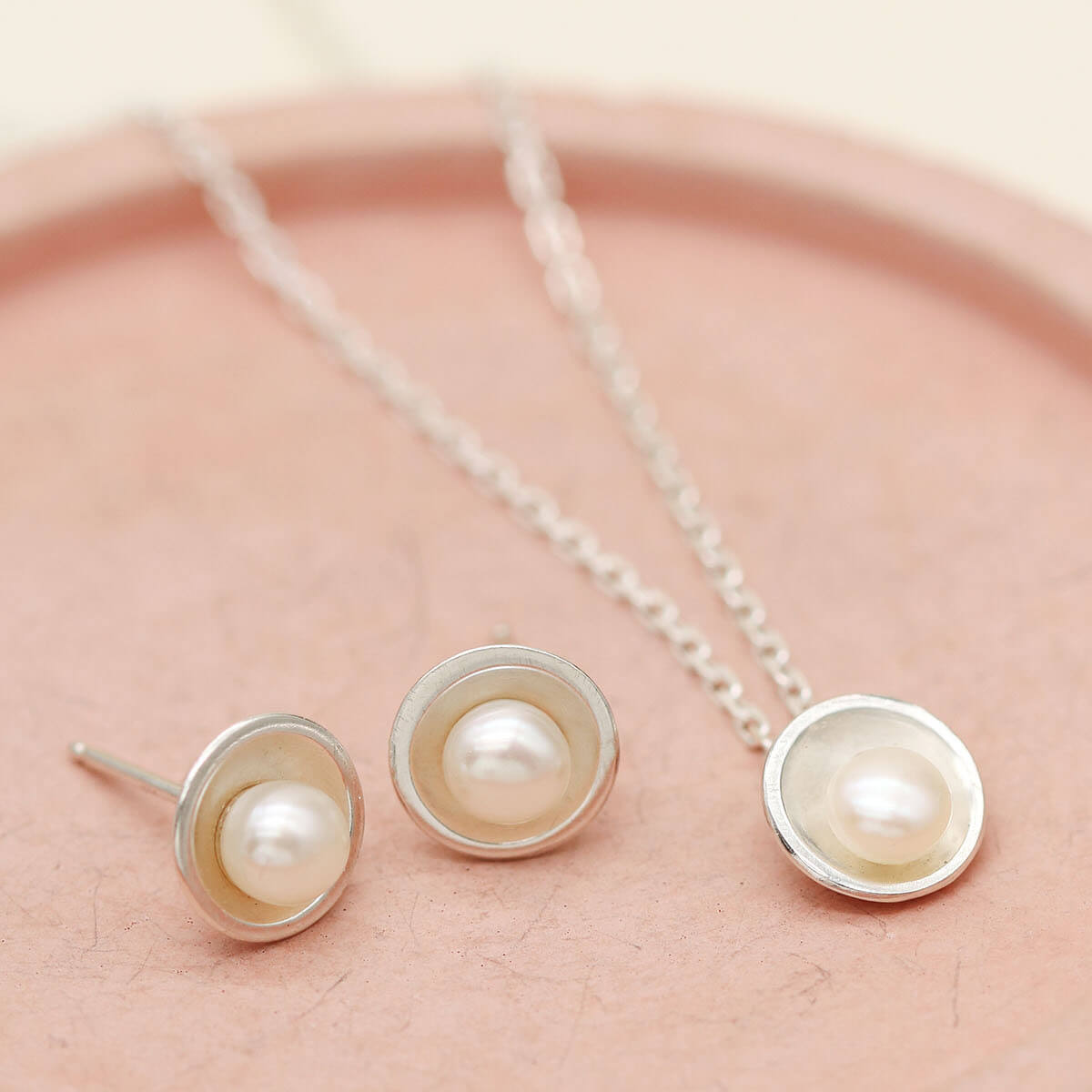 Coordinating sterling silver pearl pendant and matching freshwater pearl stud earrings handcrafted in sterling silver.