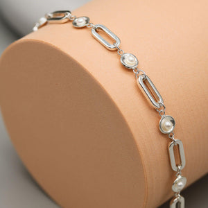 Sterling silver pearl chain bracelet handcrafted with five freshwater pearls and polished sterling silver settings on a contemporary pink display.