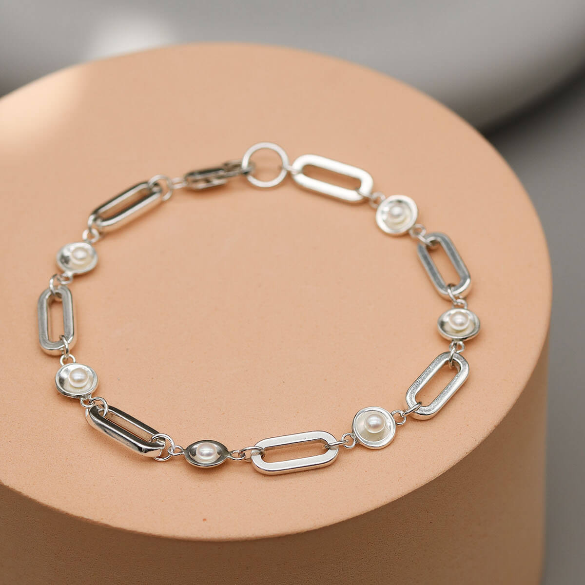 Contemporary sterling silver pearl bracelet featuring five freshwater pearls evenly spaced along a bold rectangular trace chain.