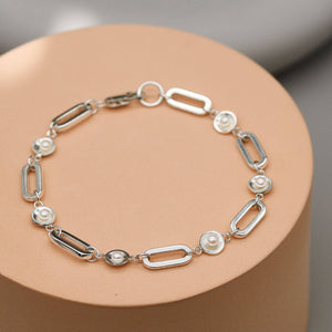 Contemporary sterling silver pearl bracelet featuring five freshwater pearls evenly spaced along a bold rectangular trace chain.