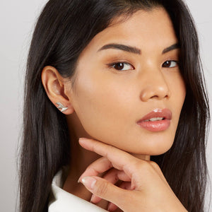 Model demonstrating art deco fan earrings from a side angle to show the sculpted edge.