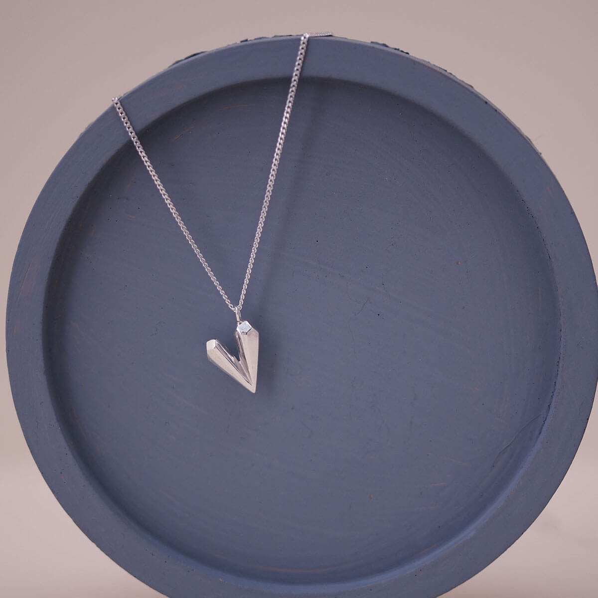 Sterling silver heart shaped necklace on a blue dish, a dainty heart necklace ideal for birthdays anniversaries or romantic gifts