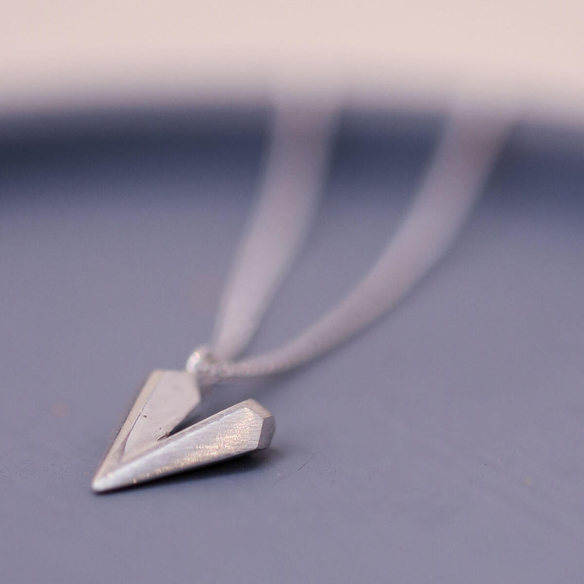 Sterling silver heart shaped necklace on a blue dish, a dainty heart necklace ideal for birthdays anniversaries or romantic gifts