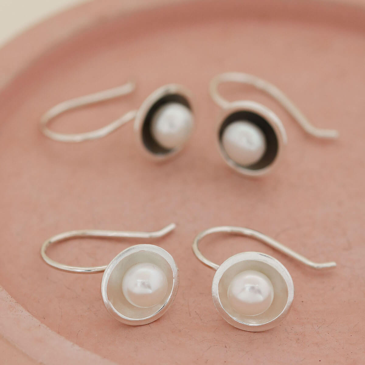 Sterling silver drop freshwater pearl earrings shown beside the matching oxidised black pearl drop earrings for comparison.
