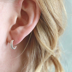 Sterling silver huggie hoop earrings modelled on the ear, small huggie hoop earrings for second holes