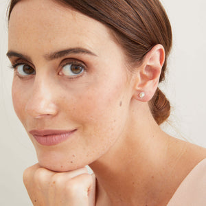 Petite freshwater pearl stud earrings modelled to show their subtle size
