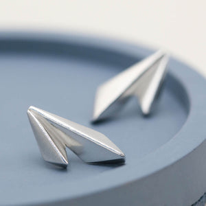 Solid silver earrings featuring a distinctive double-kite design, photographed on a deep blue dish
