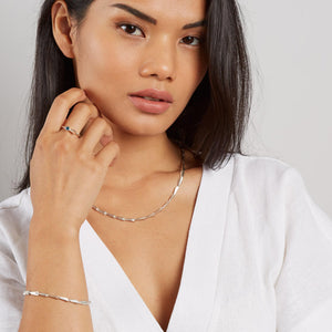 Modelled close-up highlighting how the Art Deco-inspired silver links flow around the neckline — a modern link necklace for gifting or self-treating.