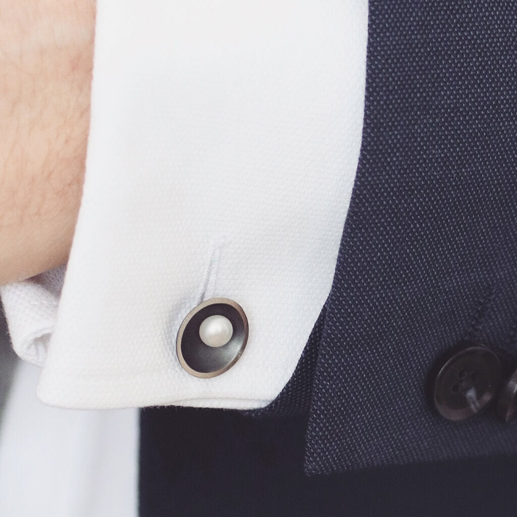 Black pearl cufflinks with oxidised silver finish worn with formal menswear and white shirt.