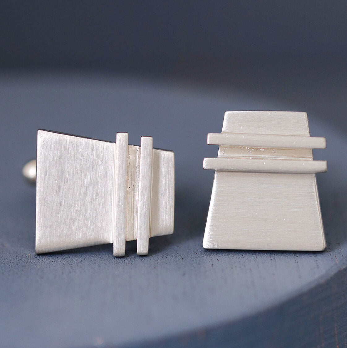Pair of Modern cufflinks on deep blue background, showing the sleek pinstripe design in polished sterling silver, perfect nice anniversary gift for husband.