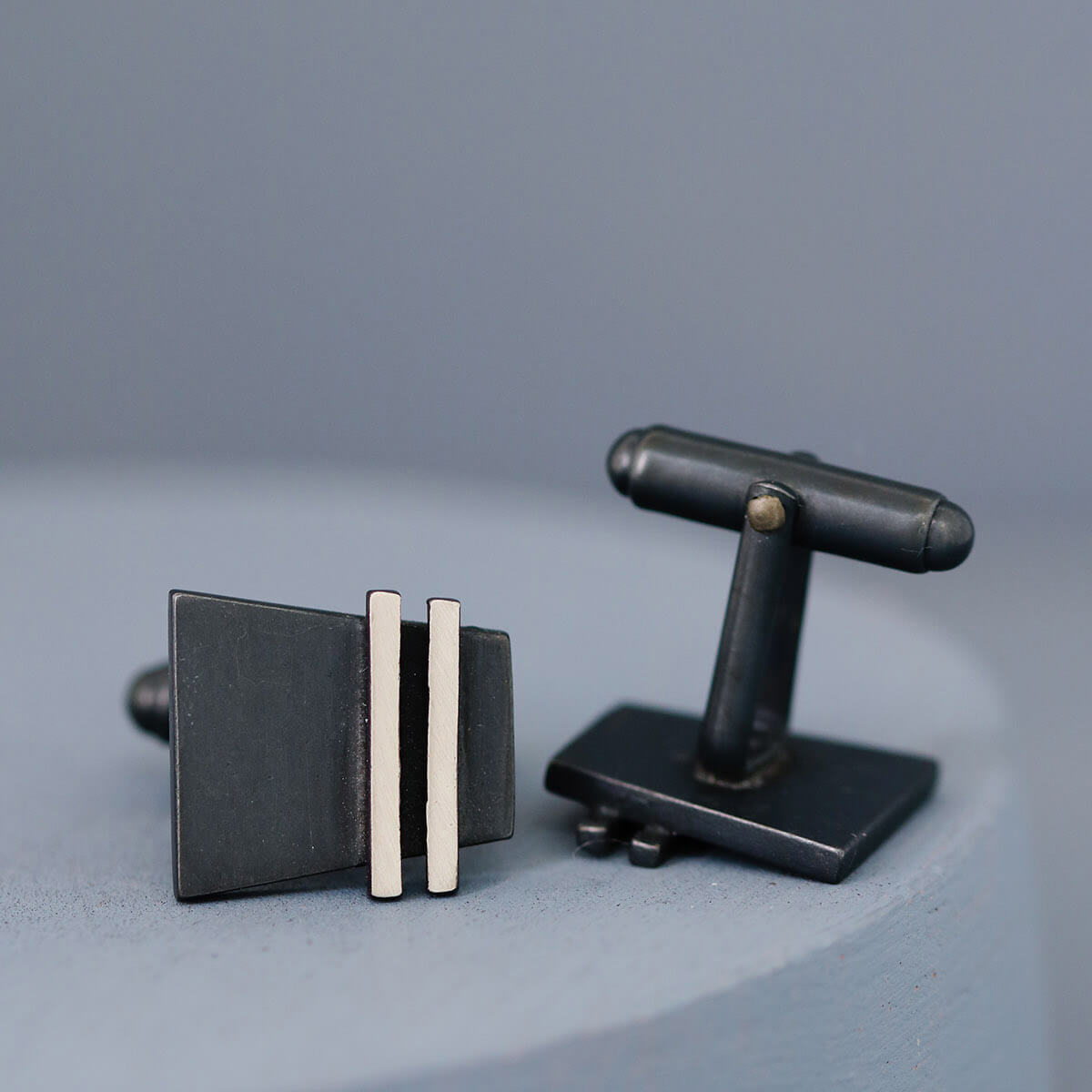 Both black cufflinks displayed at an angle to show depth and craftsmanship. Stylish accessory for weddings, birthdays, or promotions.