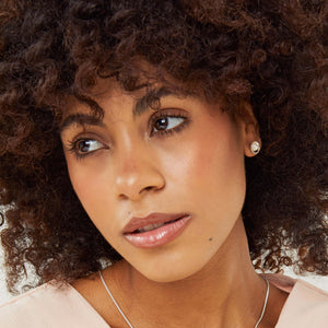 Close-up portrait of a model wearing real pearl stud earrings, showcasing refined Pearl Earrings for women in silver.