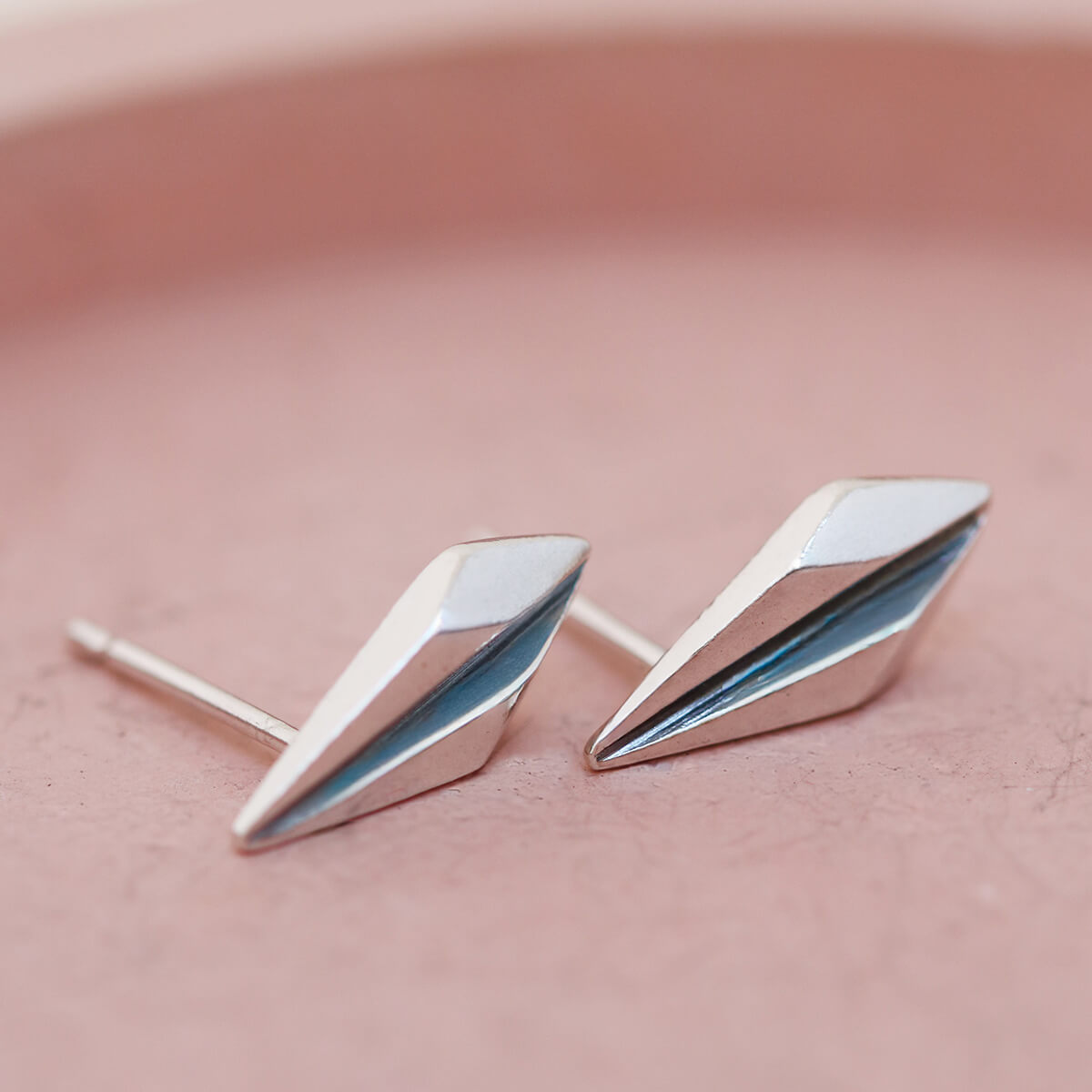 Art deco earrings studs presented on a pink dish for wedding jewellery inspiration.
