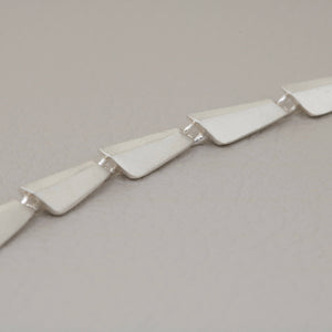 Close-up of handmade silver link necklace with sculptural geometric links and polished sterling silver finish