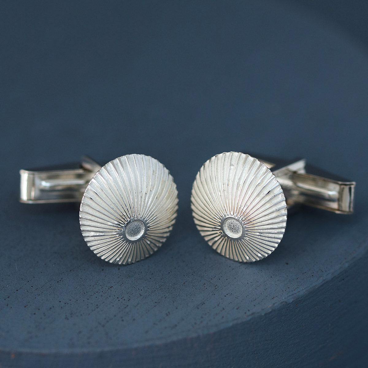 Sunburst engraved round cufflinks packaged on deep blue background – sterling silver cufflinks for graduation or promotion gift.