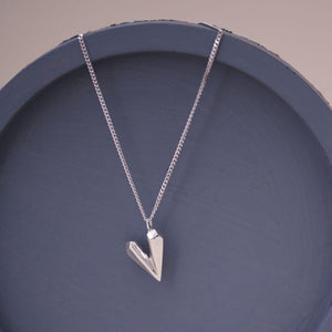 Heart shaped necklace styled on a blue dish, showcasing the handmade faceted silver heart charm on an 18 inch chain