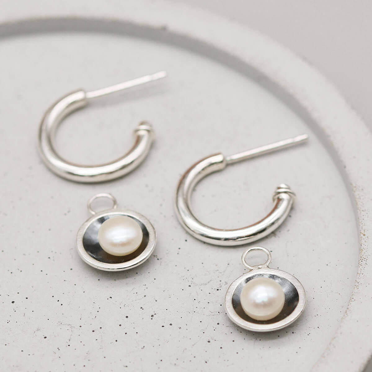 Black pearl hoop earrings with detachable freshwater pearl charms creating two elegant looks in one design.