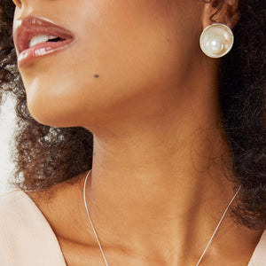 Large statement pearl earrings worn by model showing size and fit