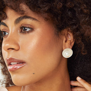 Model wearing large sterling silver pearl stud earrings