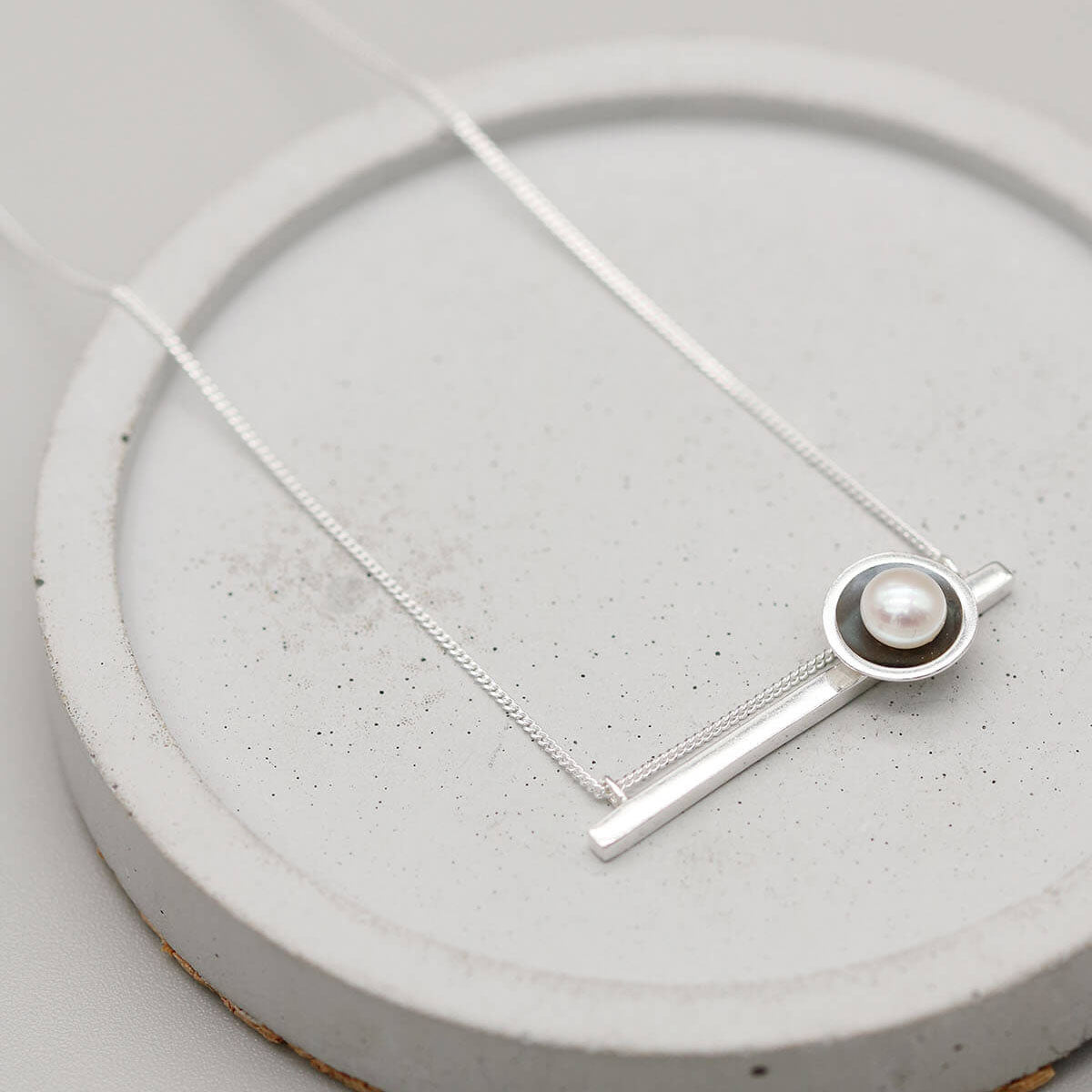 Elegant black pearl necklace with a contemporary horizontal pendant and handcrafted sterling silver finish.