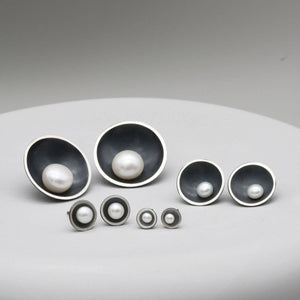Comparison of Petite, Classic, Signature and Statement black pearl stud earrings showing all four sizes side by side.