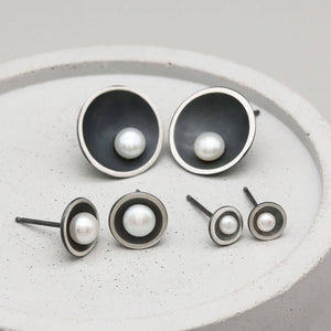 Petite, Classic and Signature black pearl stud earrings shown together for size comparison.