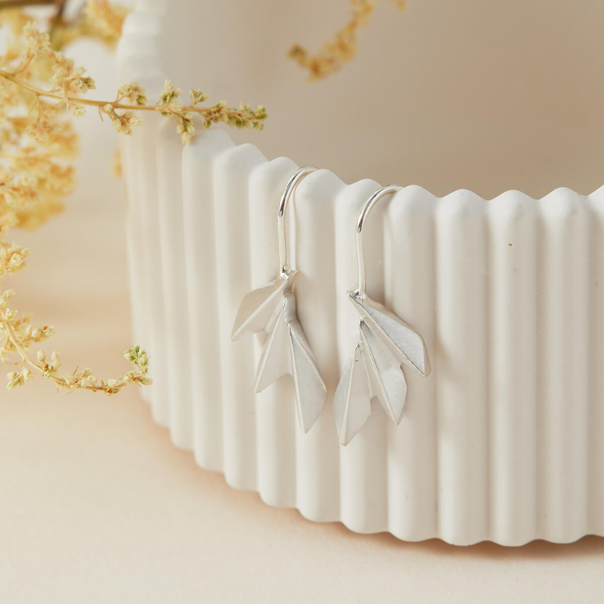 Sterling silver fan drop earrings displayed on a white dish with defined art deco lines; ideal luxury gift for anniversaries or Mother’s Day.