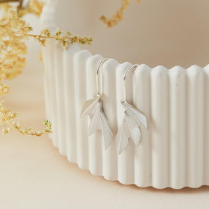 Sterling silver fan drop earrings displayed on a white dish with defined art deco lines; ideal luxury gift for anniversaries or Mother’s Day.