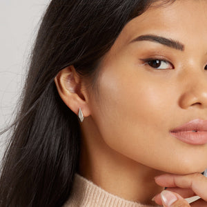 Art deco stud earrings worn on the ear, highlighting their minimalist silver detailing, ideal as art deco style earrings for bridesmaids or gifting.