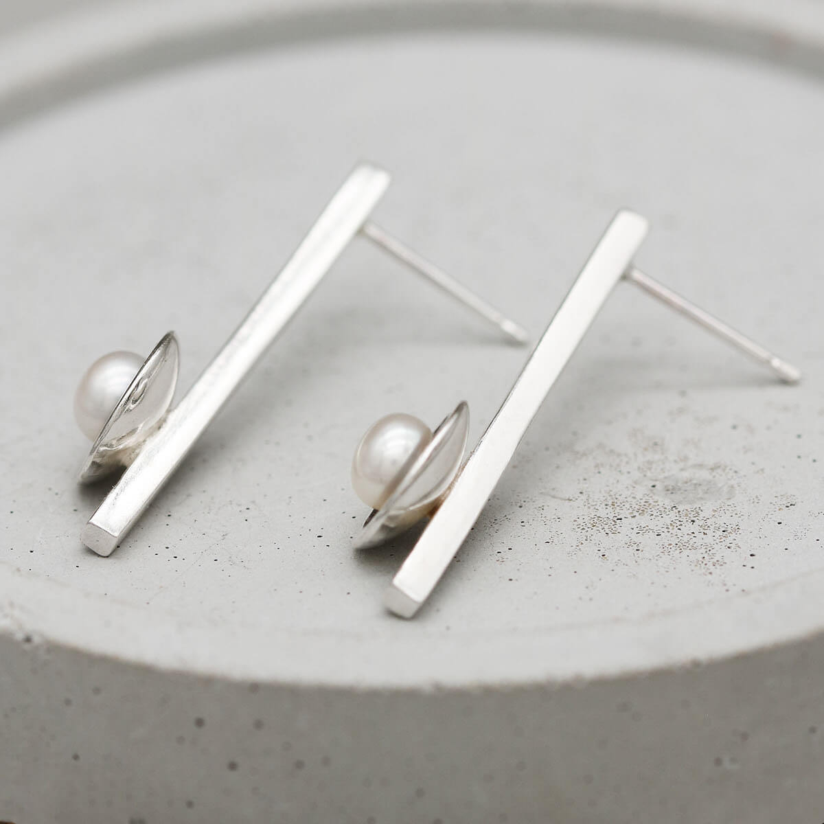Contemporary black pearl earrings with a long sterling silver bar creating a sleek elongated silhouette.