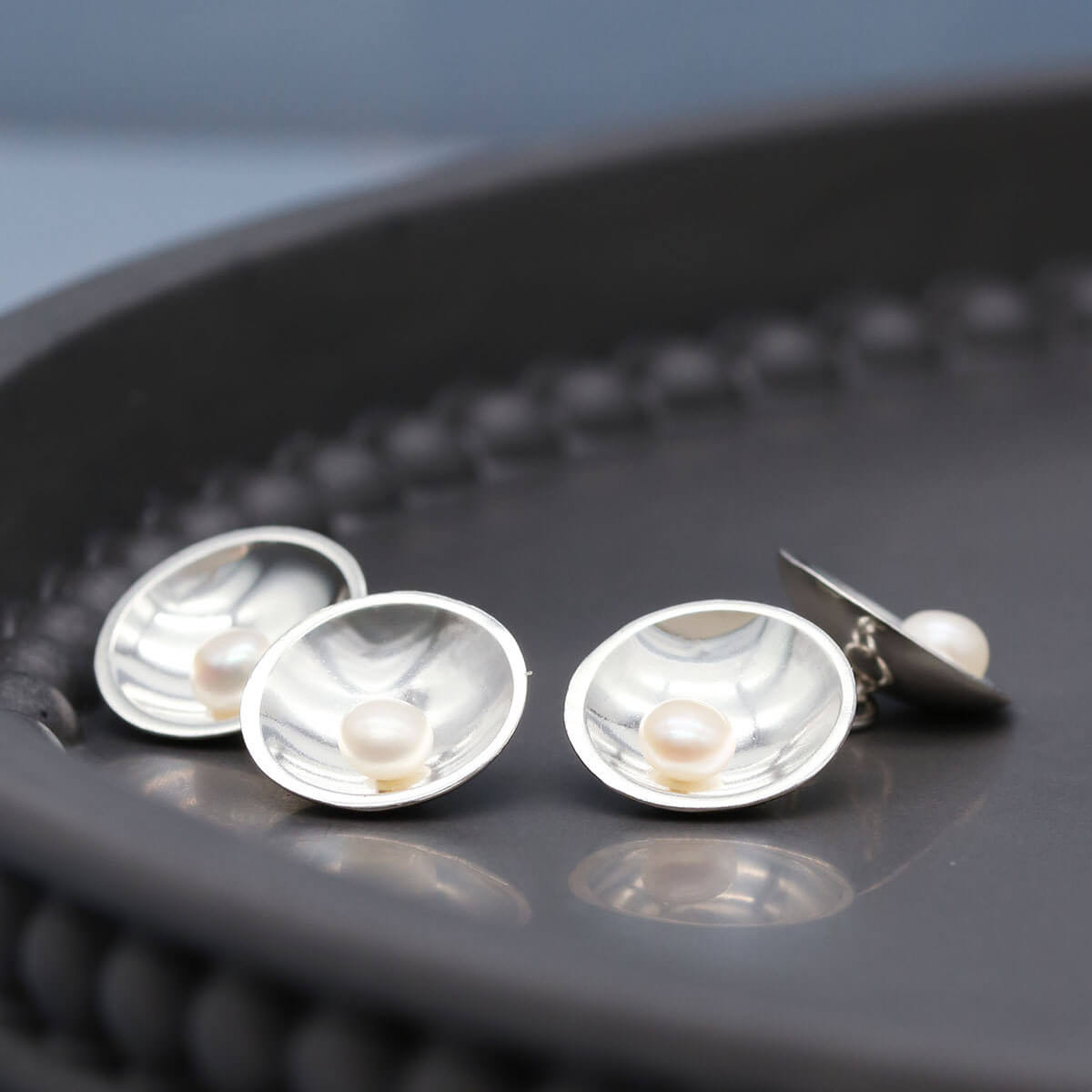 Handmade sterling silver cufflinks featuring freshwater pearls on both ends of the double-sided design.