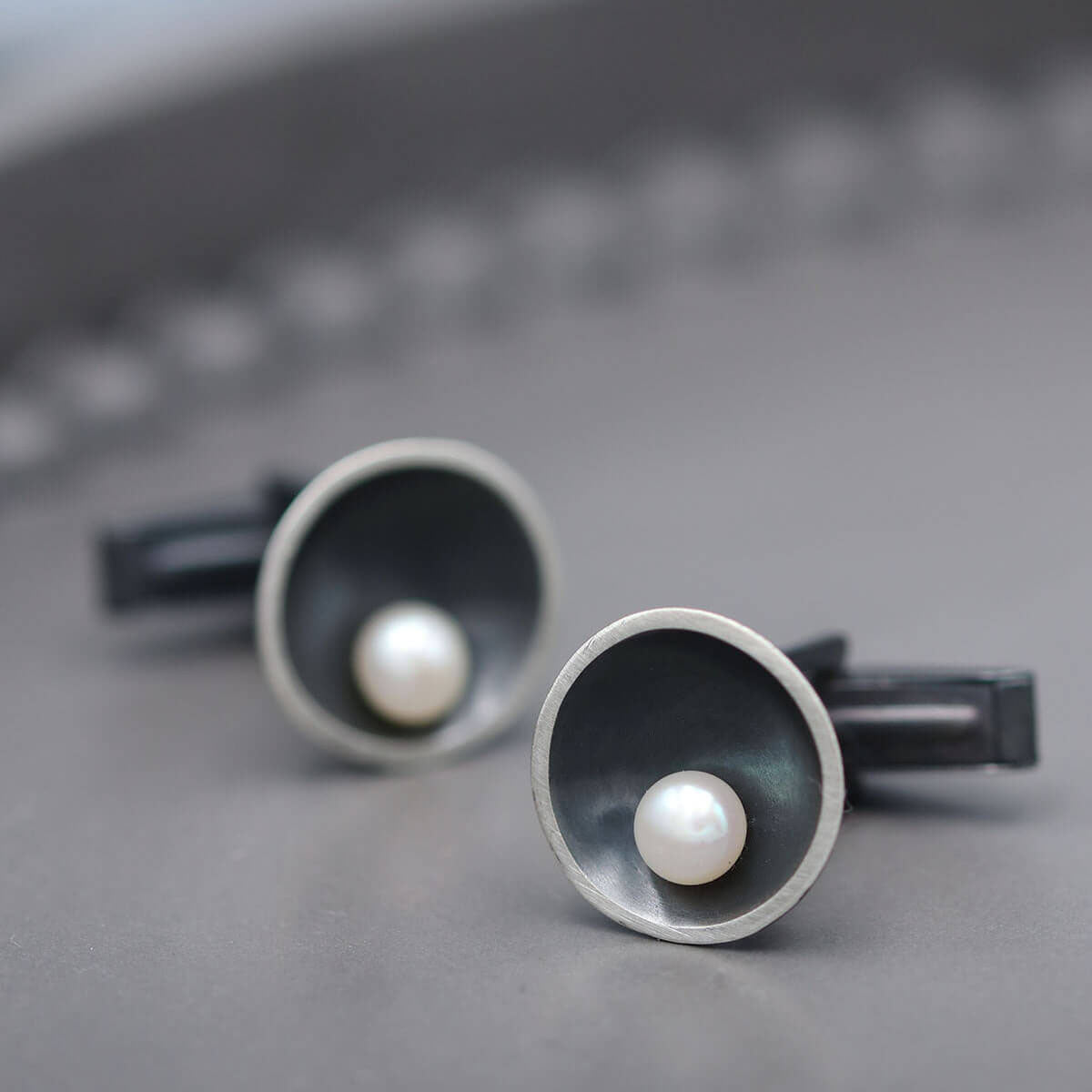 Black pearl cufflinks for men handcrafted in sterling silver with a modern Art Deco inspired design.