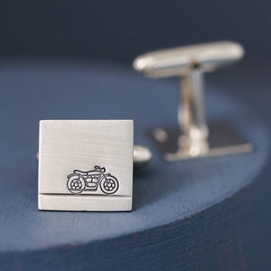 Handmade motorbike cufflinks photographed on deep blue backdrop, a thoughtful anniversary gift for a biker husband