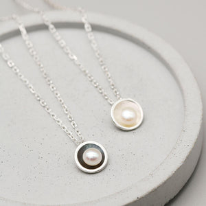 Oxidised sterling silver pearl pendant necklace displayed alongside the matching polished silver pearl pendant for comparison.
