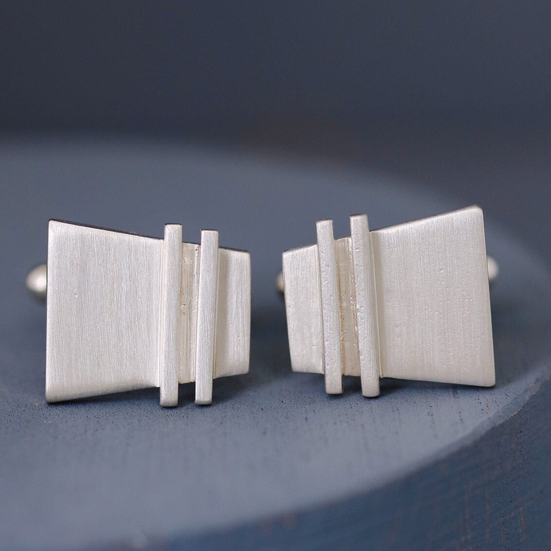 Detailed macro image of Modern cufflinks revealing fine pinstripe detailing, contemporary design for a nice anniversary gift for husband.