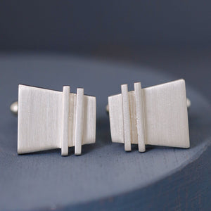 Detailed macro image of Modern cufflinks revealing fine pinstripe detailing, contemporary design for a nice anniversary gift for husband.
