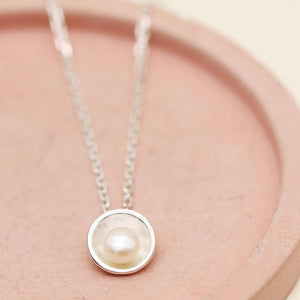 Close-up of a silver pearl pendant necklace featuring a genuine freshwater pearl in a polished sterling silver setting.