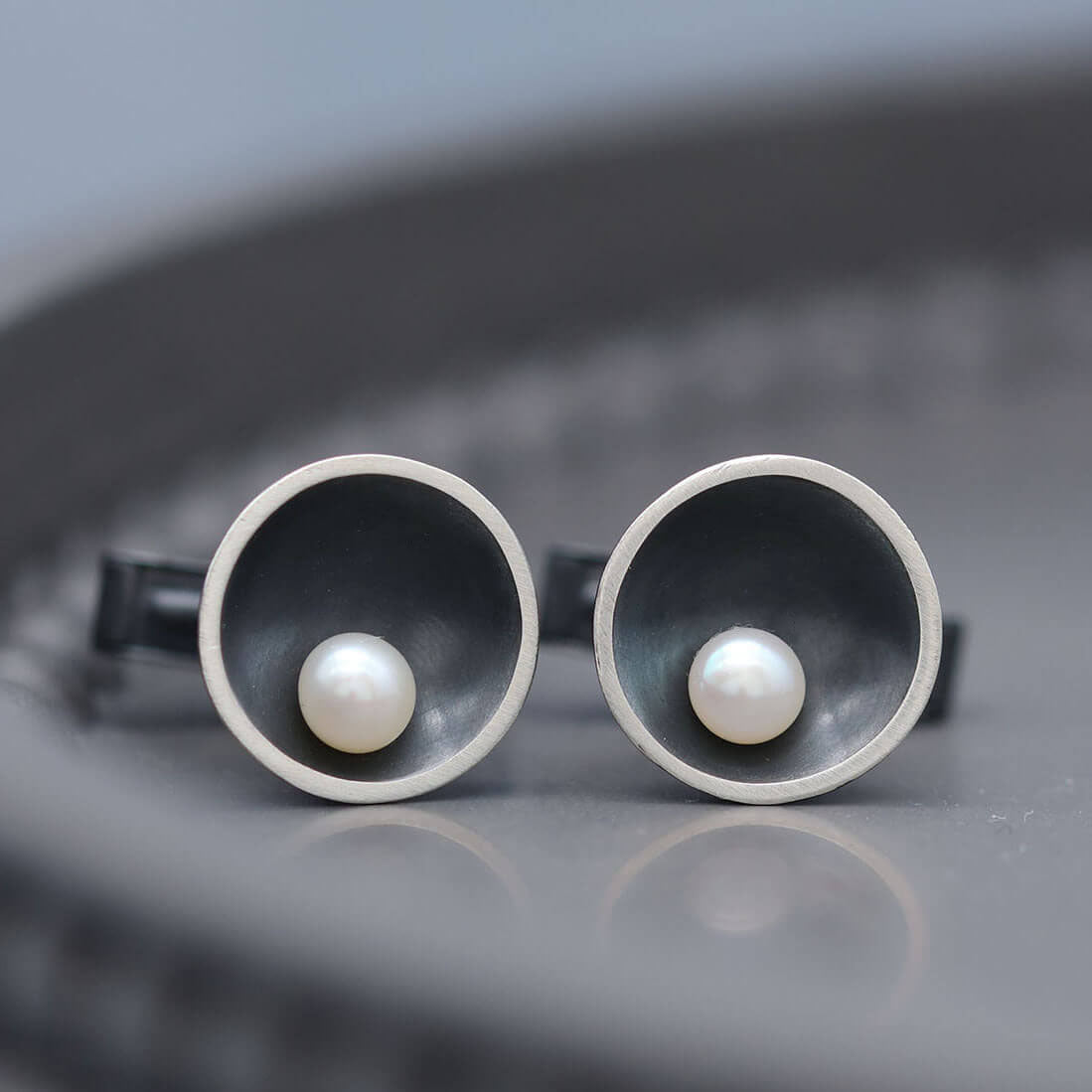 Handmade sterling silver cufflinks with black oxidised finish and genuine freshwater pearl centre detail.