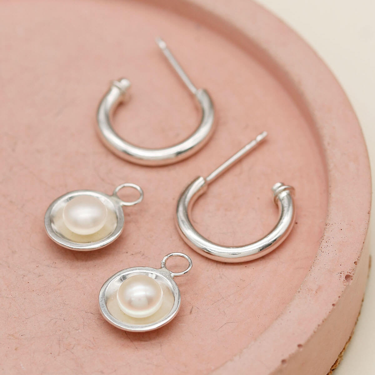 Elegant pearl drop hoop earrings with polished sterling silver hoops and genuine freshwater pearls.