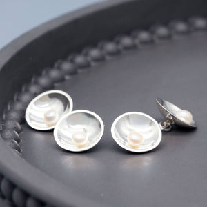 Detailed view of double-sided pearl cufflinks highlighting the lustre of freshwater pearls and polished silver finish.