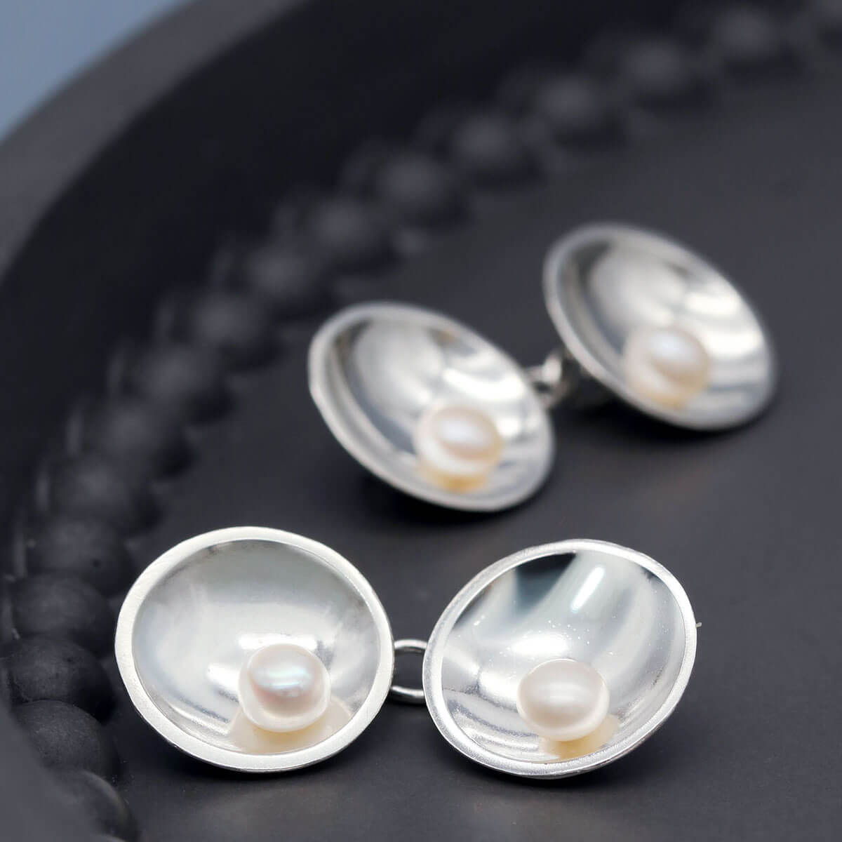 Art Deco inspired sterling silver pearl cufflinks with elegant double-sided chain design.
