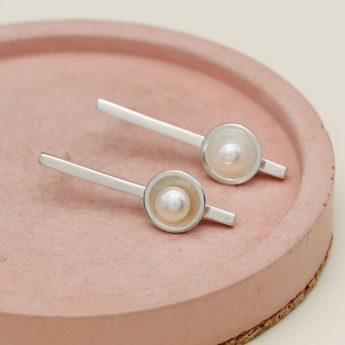 Sterling silver long pearl earrings inspired by Art Deco design with a contemporary elongated silhouette.